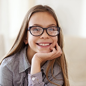 Young girl wearing glasses smiling after children's dentistry visit