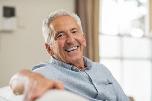 Senior man sitting on couch and smiling