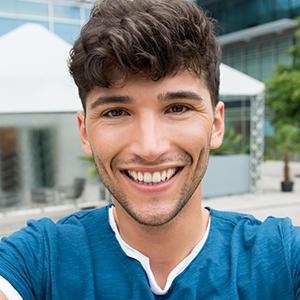 Young man with perfectly aligned teeth after orthodontics