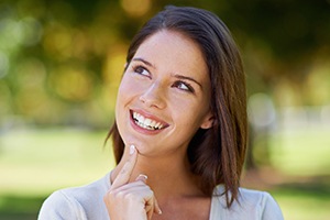 Woman looking up and smiling after gum disease treatment