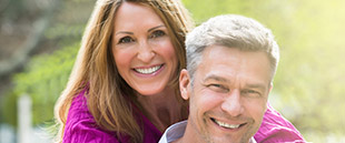 Man and woman sharing healthy smiles after restorative dentistry
