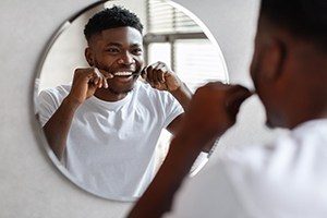 Man smiling while flossing at home